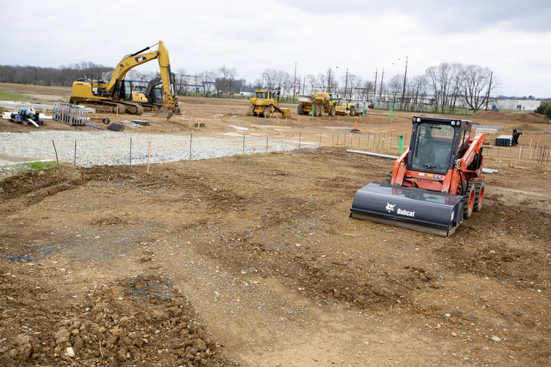 Construction site with multiple cranes and high-rise buildings, representing large-scale urban development.